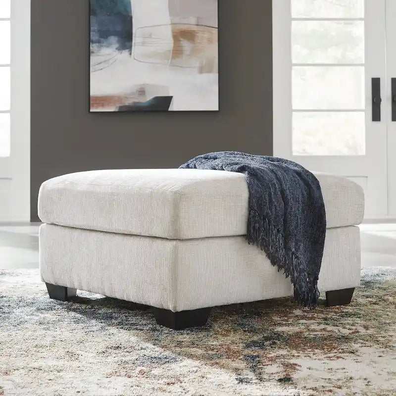Pouf poggiapiedi di grandi dimensioni rivestito con piedini a vista in simil-legno