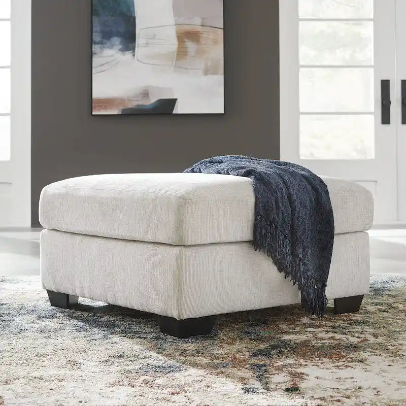 Pouf poggiapiedi di grandi dimensioni rivestito con piedini a vista in simil-legno