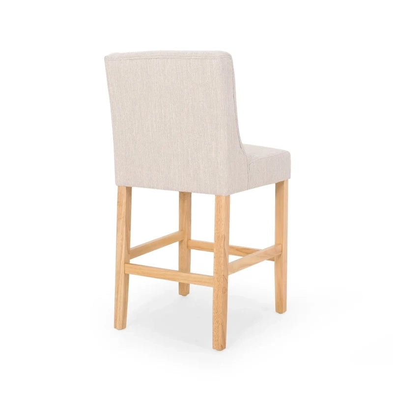 Sgabello da bancone con schienale ad ala, capitonné e gambe in legno di hevea naturale